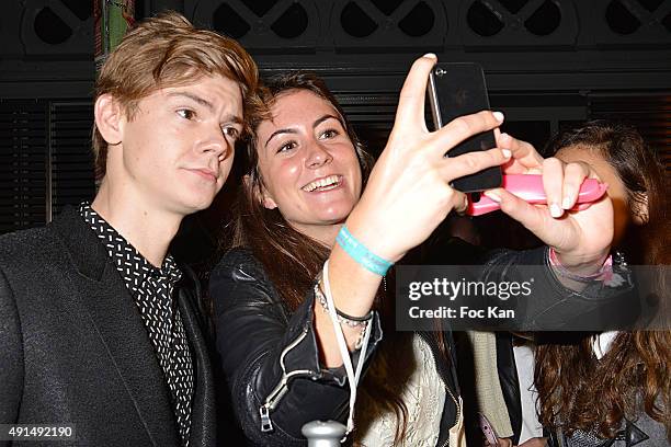 Actor Thomas Brodie Sangster poses for a selfie with an admirer during the Saint Laurent show as part of the Paris Fashion Week Womenswear...