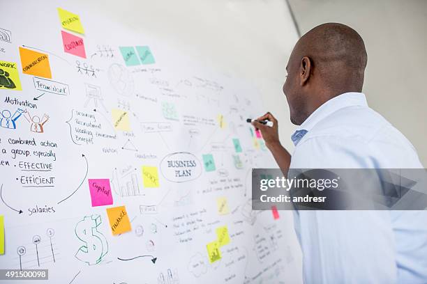 hombre de negocios afroamericano dibujando un plan - investigación de mercados fotografías e imágenes de stock