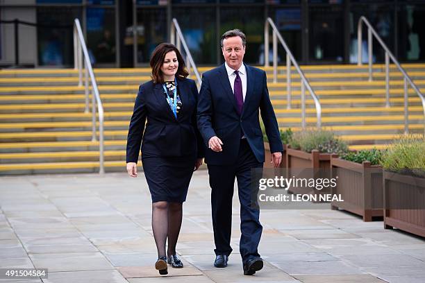 British Prime Minister David Cameron walks from the main hall with Caroline Ansell, MP for Eastbourne and Willingdon, on the third day of the annual...