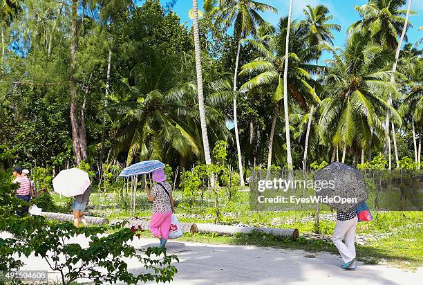 Marriage under palmtrees in white elegant clothes at the famous Source D´Argent Beach on October 01, 2015 in La Passe, La Digue, Seychelles.