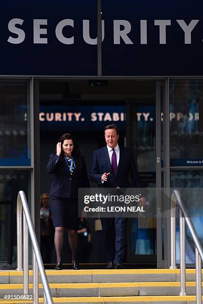 British Prime Minister David Cameron walks from the main hall with Caroline Ansell, MP for Eastbourne and Willingdon, on the third day of the annual...