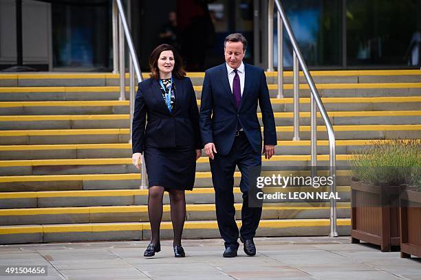 British Prime Minister David Cameron walks from the main hall with Caroline Ansell, MP for Eastbourne and Willingdon, on the third day of the annual...