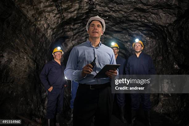 engineer leading a group of miners - ondergrond stockfoto's en -beelden