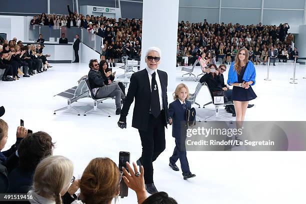 Fashion Designer Karl Lagerfeld, Hudson Kroenig and Model Cara Delevingne acknowledge the applause of the audience at the end of the Chanel show as...