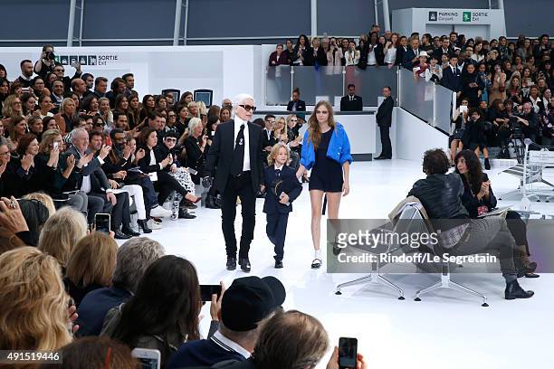 Fashion Designer Karl Lagerfeld, Hudson Kroenig and Model Cara Delevingne acknowledge the applause of the audience at the end of the Chanel show as...