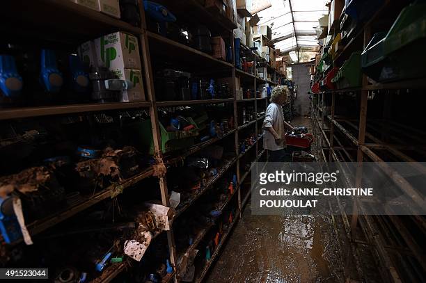 An employee of a small sized entreprise cleans up its flooded premises in Cannes, southern France, on October 6 after floods tore through the French...