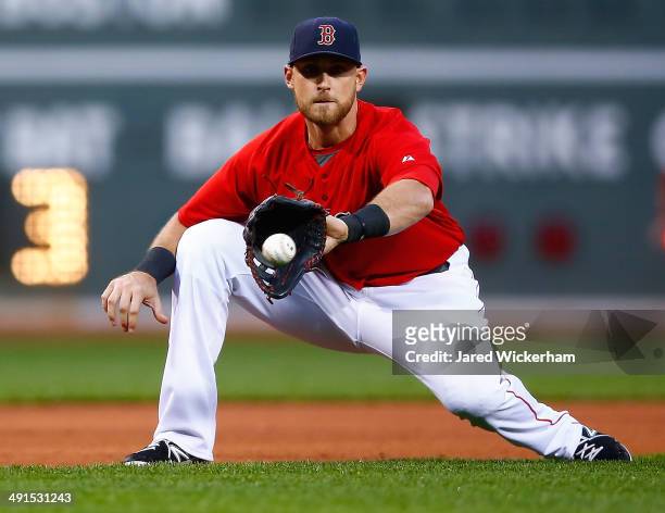Will Middlebrooks of the Boston Red Sox attempts to grab a ground ball in the first inning against the Detroit Tigers during the game at Fenway Park...