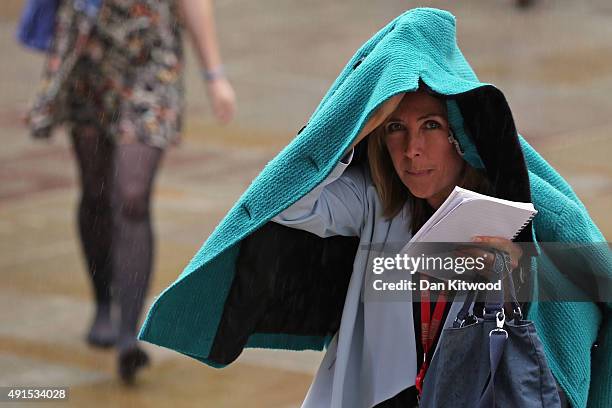 Visitors arrive in the rain for the Conservative party conference on October 6, 2015 in Manchester, England. Home Secretary Theresa May is due to...