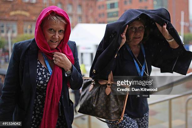 Visitors arrive in the rain for the Conservative party conference on October 6, 2015 in Manchester, England. Home Secretary Theresa May is due to...