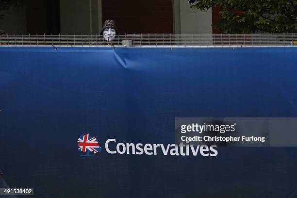 Protester peers over the security fence surrounding Manchester Central during the Conservative Party Conference on October 6, 2015 in Manchester,...