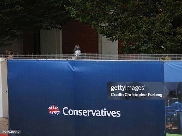 Protester peers over the security fence surrounding Manchester Central during the Conservative Party Conference on October 6, 2015 in Manchester,...