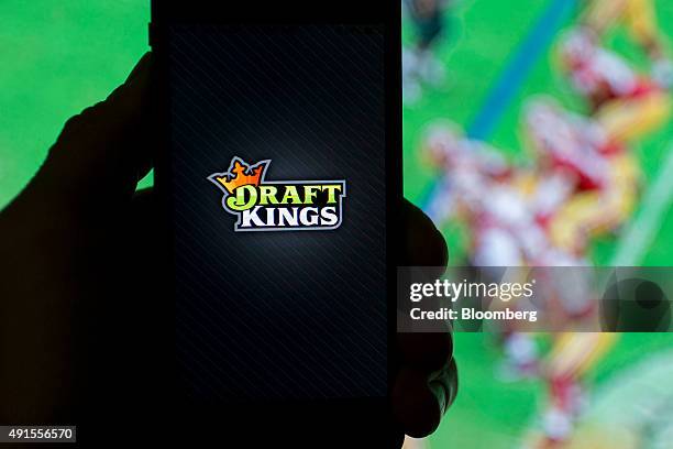 The DraftKings Inc. Logo is arranged for a photograph on an Apple Inc. IPhone in Washington, D.C., U.S., on Sunday, Oct. 4, 2015. Fantasy sports...