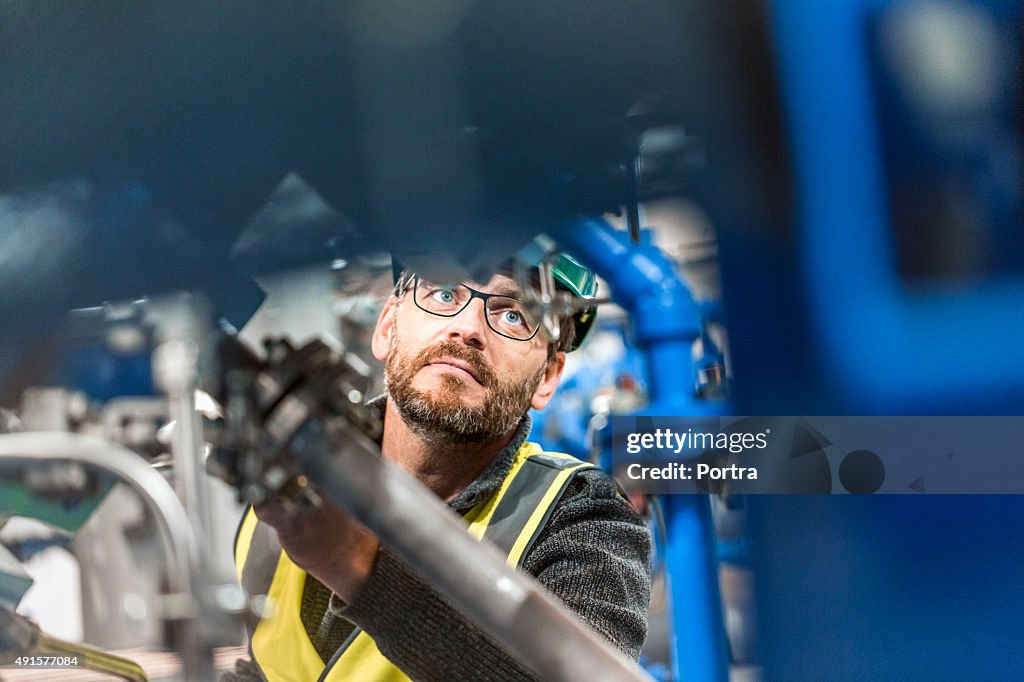 Hombre de examinar la máquina en fábrica profesional