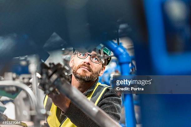 male professional examining machine at factory - manufacturing equipment stock pictures, royalty-free photos & images