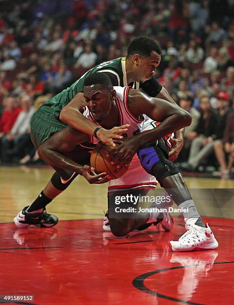 Bobby Portis of the Chicago Bulls battles for the ball with John Henson of the Milwaukee Bucks during a preseason game at the United Center on...