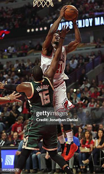 Jimmy Butler of the Chicago Bulls puts up a shot over Greg Monroe of the Milwaukee Bucks during a preseason game at the United Center on October 6,...