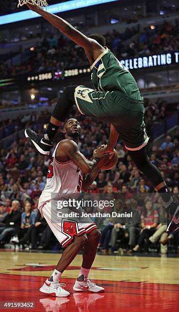 Damien Inglis of the Milwaukee Bucks leaps over E'Twaun Moore of the Chicago Bulls during a preseason game at the United Center on October 6, 2015 in...