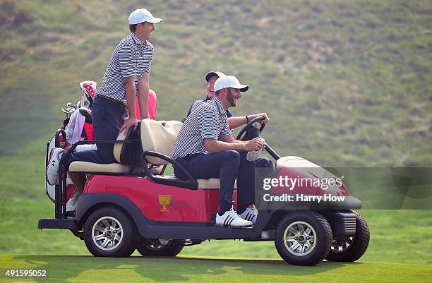 Dustin Johnson and Jordan Spieth of the United States team get a ride from Jim Furyk during a practice round prior to the start of The Presidents Cup...