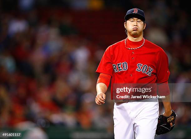 Junichi Tazawa of the Boston Red Sox walks off of the field following the top of the 9th inning against the Detroit Tigers during the game at Fenway...