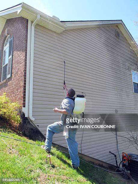 By Ivan Couronne, USA-alcool-procès-viticulture-boissons A worker of West Home Maintenance sprays a bleach-based product on the gutters of a house...