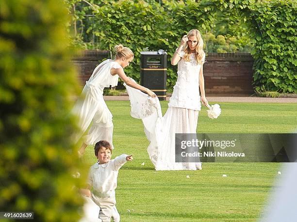 Poppy Delevingne and Cara Delevingne are seen at Poppy Delevingnes and James Cook's wedding reception held in Kensington Palace Gardens on May 16,...