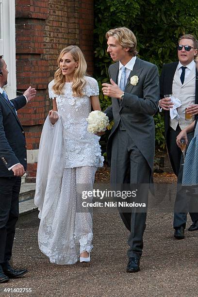 James Cook and Poppy Delevingne are seen at Poppy Delevingnes and James Cook's wedding reception held in Kensington Palace Gardens on May 16, 2014 in...