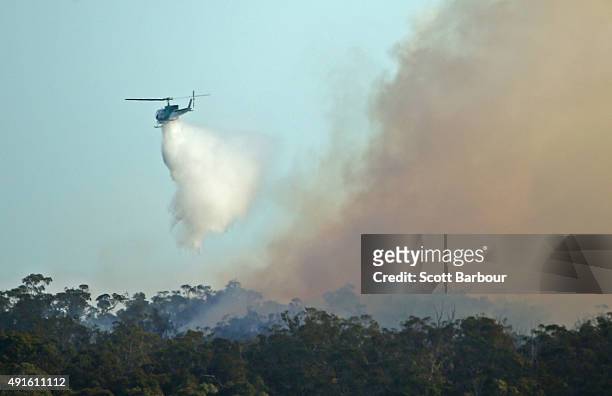 Water bombing helicopter dumps water on a bushfire in Lancefield, Victoria on October 7, 2015 near Melbourne, Australia. Victorian fire crews have...