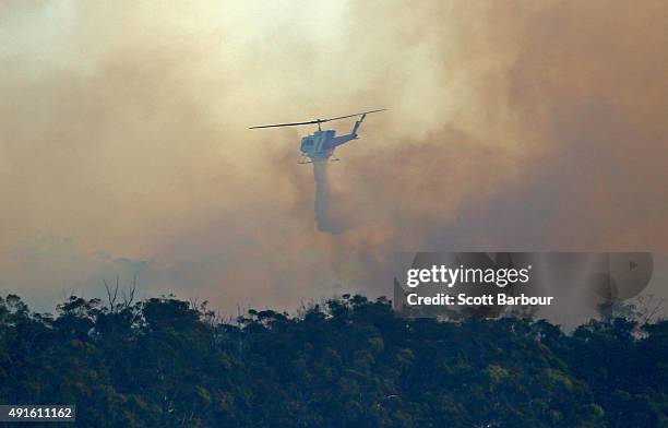 Water bombing helicopter dumps water on a bushfire in Lancefield, Victoria on October 7, 2015 near Melbourne, Australia. Victorian fire crews have...