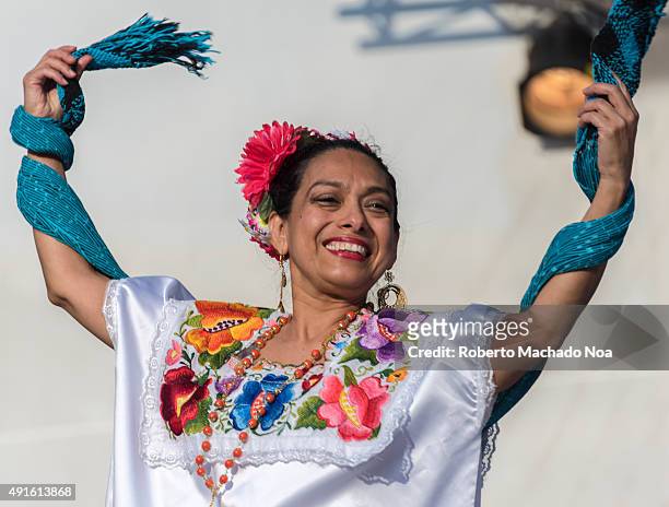 Woman performing the Flamenco folk dance on stage, with a shawl as a prop, at MexFest 2015 in Toronto. The woman is wearing a white velvet dress with...