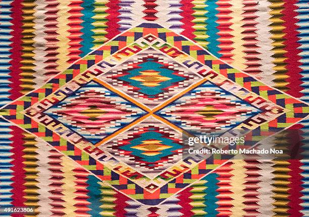 Full frame shot of Mexican native art pattern on a cloth. The art has vertical zig-zag color patterns with four squares in the center. The Textiles...