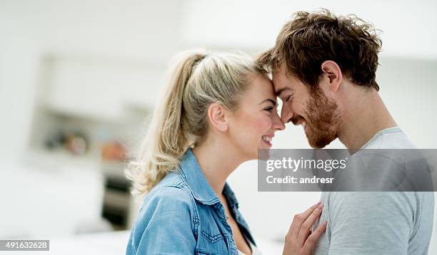 affectionate couple looking happy at home - couple kissing stock pictures, royalty-free photos & images