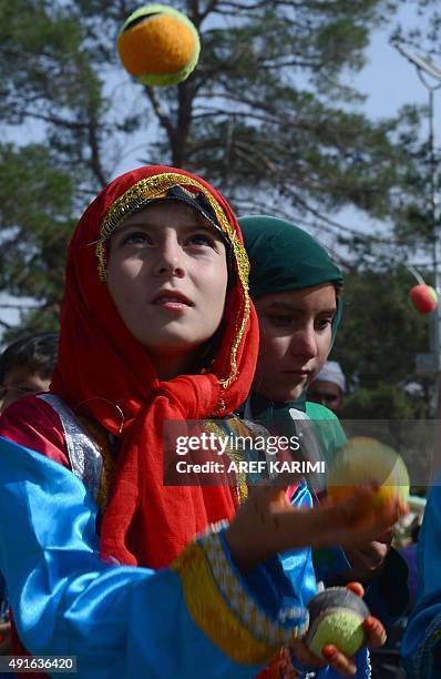 Afghan children from The Mobile Mini Circus for Children juggle with balls during a circus show in Herat on October 7, 2015. AFP PHOTO/Aref KARIMI