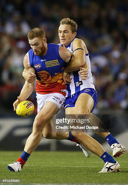 Drew Petrie of the Kangaroos tackles Daniel Merrett of the Lions during the round nine AFL match between the North Melbourne Kangaroos and the...