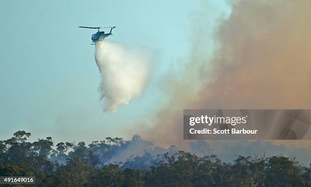 Water bombing helicopter dumps water on a bushfire in Lancefield, Victoria on October 7, 2015 near Melbourne, Australia. Victorian fire crews have...