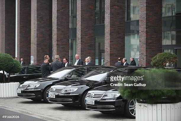 Men stand next to the cars of Volkswagen board members outside the building where the board members met and elected Hans Dieter Poetschas new...
