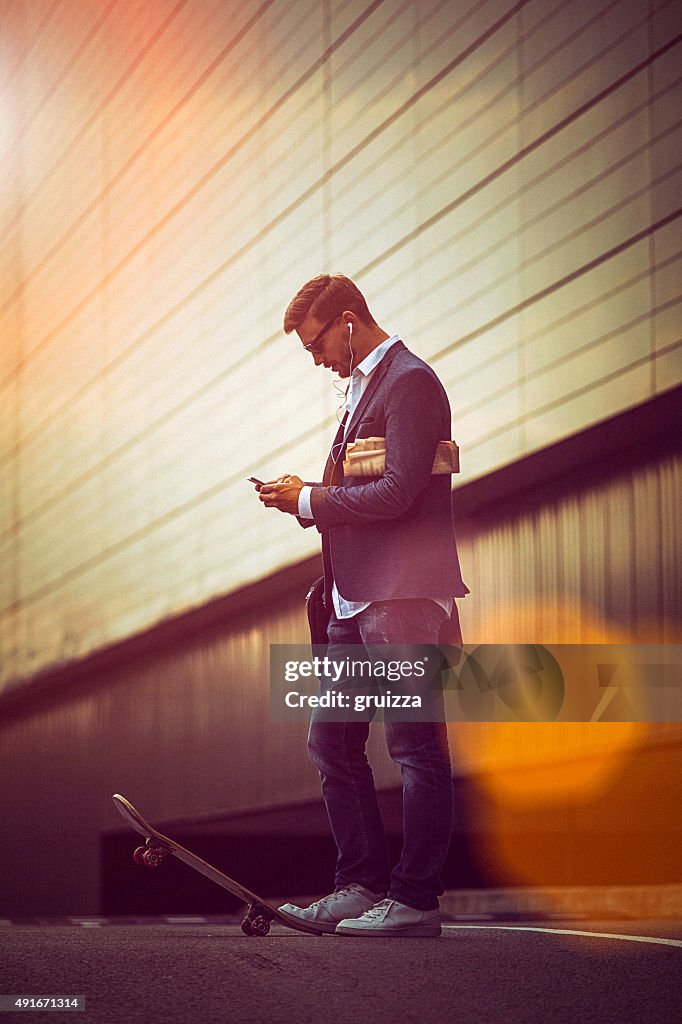 Casual jeune homme d'affaires à l'aide de smartphone dans l'urban environme
