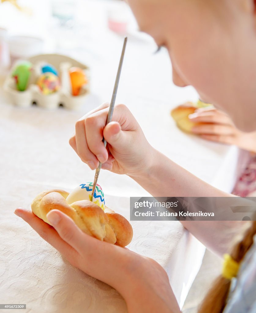 A young girl decorating Easter cakes