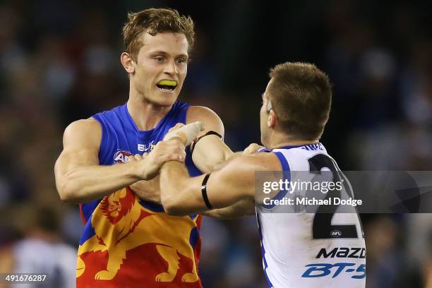 Luke McDonald of the Kangaroos and James Aish of the Lions wrestle behind play during the round nine AFL match between the North Melbourne Kangaroos...