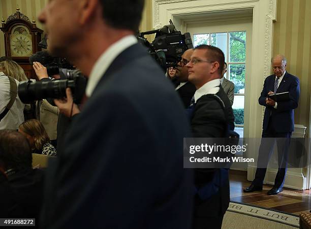 Vice President Joseph Biden listens to US President Barack Obama and German President Joachim Gauck speak during a meeting in the Oval Office at the...