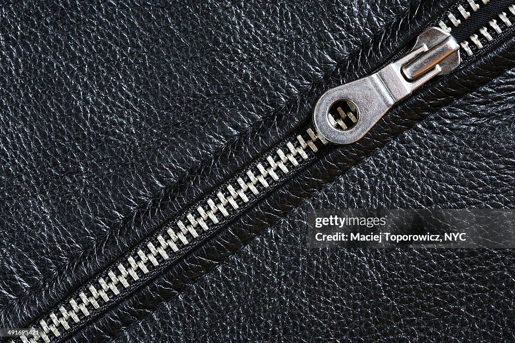 Close-up of a zipper in black leather jacket