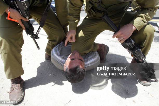 Israeli soldiers detain a Palestinian protester during a gathering by Palestinian, Israeli and foreign demonstrators in support of Palestinian...