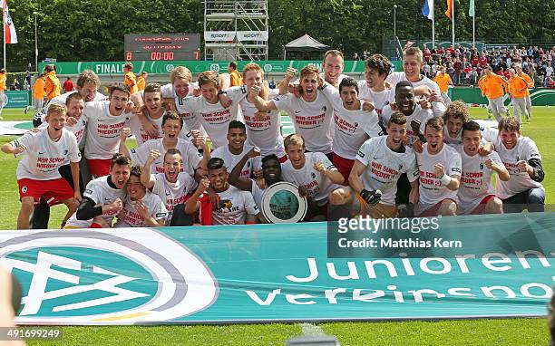 The team of Freiburg pose with the Cup after winning the DFB Juniors Cup final match between SC Freiburg and FC Schalke 04 at Stadion am Wurfplatz on...