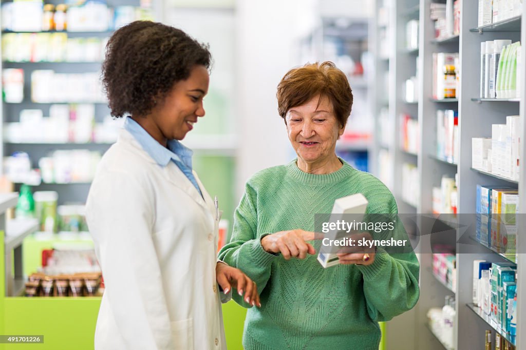African American pharmacist assisting to a senior woman.