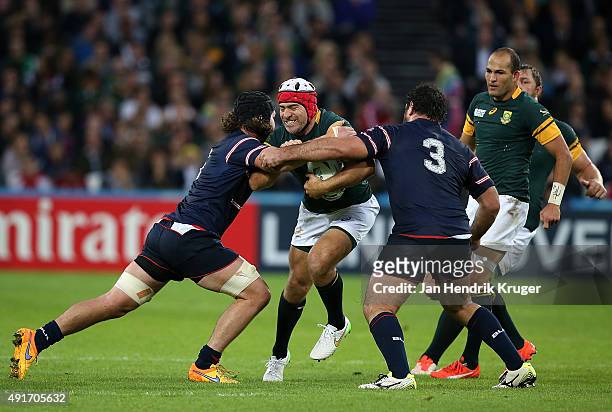 Schalk Brits of South Africa is tackled by Danny Barrett and Chris Baumann of the United States during the 2015 Rugby World Cup Pool B match between...