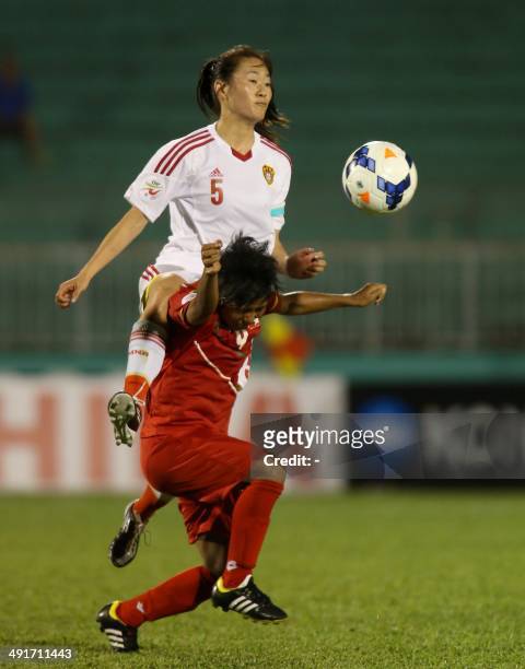 Chinese defender Wu Haiyan fights for the ball with Myanmar's defender San San Maw during the Women's Asia Football Cup match between China and...