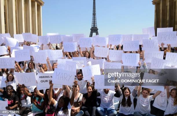 French TV show host Cyril Hanouna and schoolgirls holding placards bearing the first names of the 223 Nigerian schoolgirls held hostage in Nigeria,...