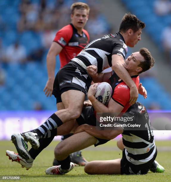 Matty Ashurst of Salford Red Devils is tackled by Dave Allen and Willie Isa of Widnes Vikings during the Super League match between Widnes Vikings...