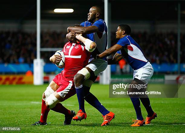 Mamuka Gorgodze of Georgia is tackled high by Tjiuee Uanivi of Namibia and Eugene Jantjies of Namibia during the 2015 Rugby World Cup Pool C match...