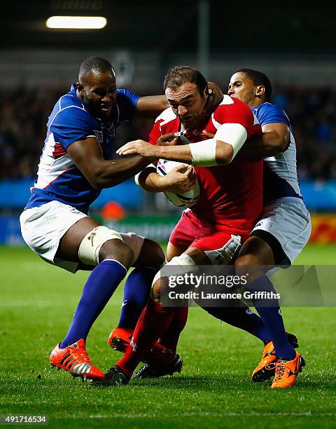 Mamuka Gorgodze of Georgia is tackled high by Tjiuee Uanivi of Namibia and Eugene Jantjies of Namibia during the 2015 Rugby World Cup Pool C match...