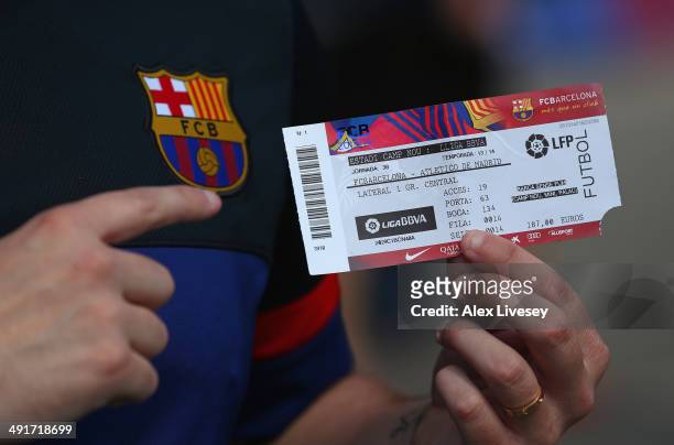 Supporter of FC Barcelona shows off his match ticket prior to the La Liga match between FC Barcelona and Club Atletico de Madrid at Camp Nou on May...